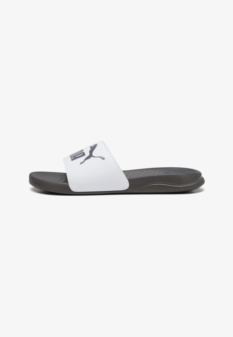 Białe klapki z szerokim paskiem, z czarnym logo Puma, szarym teksturowanym wkładką i czarną trwałą podeszwą. Minimalistyczny design.