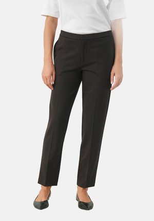 Pantaloni negri potriviți, cu un design cu picior drept, având o textură fină și o talie medie, asortați cu încălțăminte plată neagră.