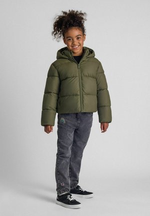 Olive green puffer jacket with a hood, zip closure, and quilted design paired with dark gray jeans featuring rainbow and heart embroidery.