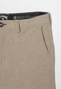 Shorts beiges en tissu texturé, avec une fermeture par bouton, des poches latérales inclinées et une ceinture de marque avec des coutures contrastées.