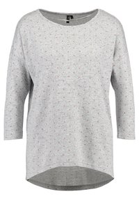 Grå stickad topp med rund halsringning, trekvartslånga ärmar och små rosa prickar. Har en böjd fåll för extra stil.