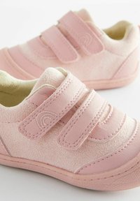 Scarpe da bambino rosa in suede e materiale sintetico, con due cinturini in velcro, punta arrotondata e dettagli testurizzati.