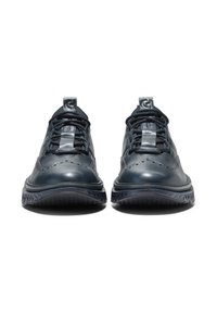 Donkerblauwe leren schoenen met geperforeerd design, gestructureerde zool en platte veters. Metallisch logo op de tong, duurzame constructie en sportieve uitstraling.