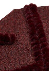 Burgunderrot und schwarze gewebte Decke mit strukturiertem Finish, verziert mit einem weichen Kunstfellrand entlang der Kanten für zusätzliche Details.