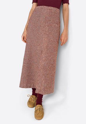 Gonna lunga con motivo marrone e silhouette dritta, realizzata in un tessuto testurizzato e con uno spacco laterale, abbinata a scarpe marroni con lacci e calze bordeaux.