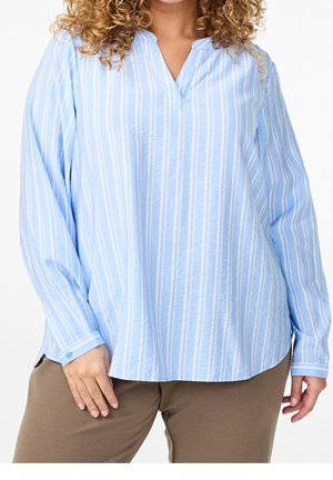 Blouse bleu clair à manches longues avec des rayures verticales blanches, décolleté en V et fentes sur les côtés. Le tissu semble léger avec une texture douce.