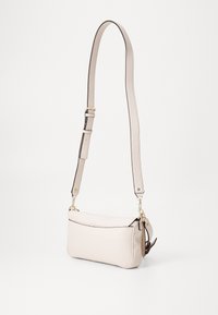 Borsa a tracolla in pelle beige chiaro con una forma strutturata, dotata di una tracolla removibile, hardware dorato e una superficie leggermente texturizzata.