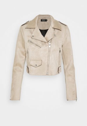 Veste courte en daim beige avec fermeture éclair asymétrique devant, trois poches zippées, poche à rabat et épaulettes.