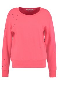 Felpa in pile di un vivace colore rosa, con scollatura tonda e maniche lunghe. Decorata con ricami di stelle nere e geometrici sul davanti.