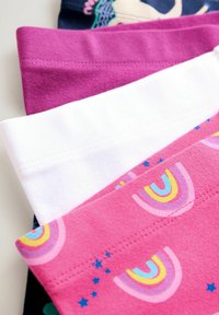 Gomila presavijenih šarenih tkanina s jednobojnim magenta, običnim bijelim i roza uzorcima s duginim bojama i zvjezdicama na svijetloj podlozi.