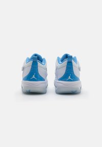 Sneaker bianchi con accenti blu, caratterizzati da un design curvo, tessuto strutturato e un logo distintivo sul tallone e sulla suola.