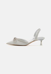 Čevlji s koničastim prstom in slingback stilom iz srebrnega blaga, okrašeni z vozlom in kristalnimi detajli, z prozornim akrilnim petnikom in kovinskim zaključkom.