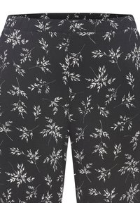 Melni legingi ar baltu botānisku lapu rakstu; stiepjas audums; elastīga jostasvieta; piegulošs dizains bez redzamām detaļām.