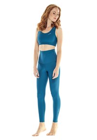Türkises Sportoutfit bestehend aus einem kurzen Oberteil und hochgeschnittenen Leggings, gefertigt aus glattem, dehnbarem Stoff mit einer figurbetonten Silhouette.