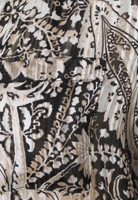 Tissu fluide avec un motif floral abstrait en noir, beige et blanc, présentant des détails complexes. Inclut une texture subtile et des lignes verticales.