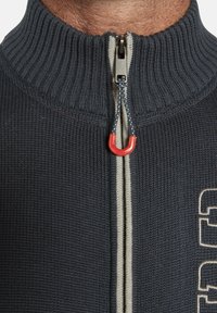 Navy Zip-Up-Pullover mit geripptem Kragen und Rumpf, mit einem kontrastierenden grauen Reißverschluss und einem roten Reißverschluss-Zipper. Mit Logo-Detail auf der Vorderseite.