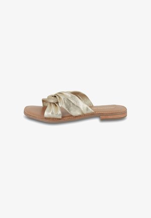 Gold metallic slide sandal with a knotted front strap, smooth leather sole, and exposed stitching. Open design, flat heel, minimalistic style.