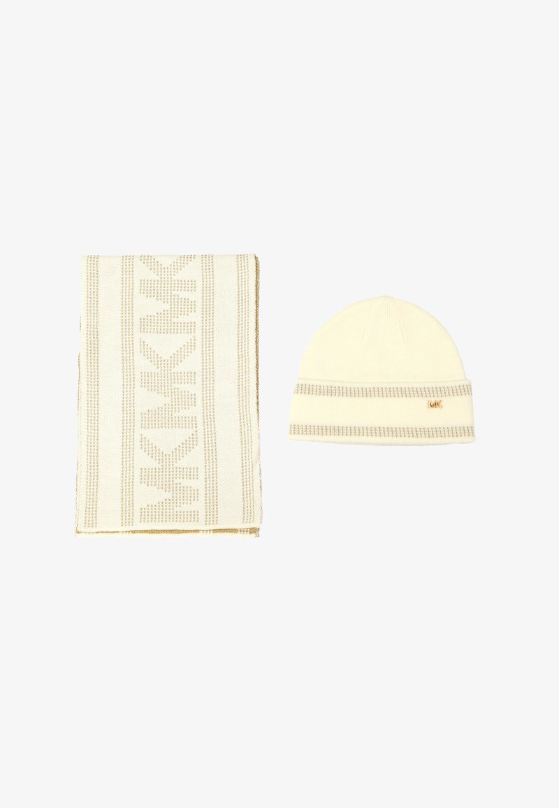 Bufanda de lana color crema con rayas estampadas y un gorro a juego. Ambos presentan un sutil acento dorado y un detalle del logo en el gorro.