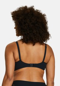 Top de bikini noir à côtes avec des bretelles ajustables et une fermeture à crochet au dos. Fabriqué dans un tissu texturé pour plus de détails.