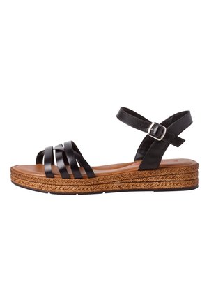 Zwarte leren sandaal met kruislingse banden, bruin gevoerd voetbed en een gevlochten jute-wikkelzool. Verstelbare enkelsluiting.