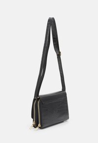 Černá kabelka z umělé krokodýlí kůže se strukturovaným tvarem, zlatými zipovými akcenty a tenkým nastaviteľným popruhem.