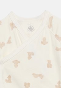 Μπλουζάκι τύλιγμα για μωρό σε εκρού χρώμα με σχέδια αρκουδάκι και σκύλο σε ανοιχτό καφέ, μέγεθος 12 μηνών, λογότυπο μάρκας στο εσωτερικό του γιακά.