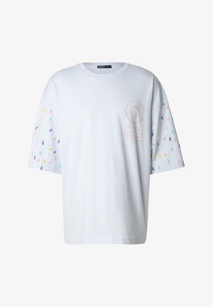 Maglietta a maniche corte azzurro chiaro con motivi colorati a spruzzo sulle maniche e un semplice disegno grafico sul davanti.