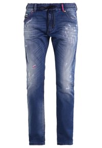 Pantalones de mezclilla azul con un corte relajado, cinturilla elástica, cordón, detalles desgastados y ligeras decoloraciones para un aspecto usado.