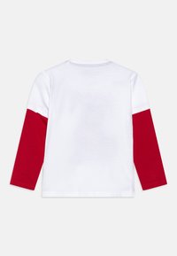 Langermet skjorte med hvit kropp og røde ermer. Laget av bomull med rund hals. Ingen synlige logoer eller mønstre på baksiden.