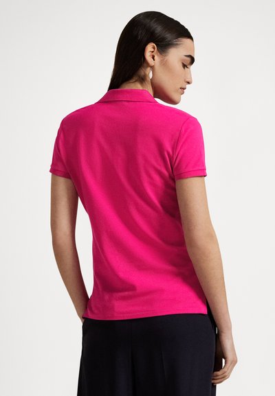 Εφαρμοστό πόλο μπλουζάκι σε έντονο ροζ χρώμα, με κοντά μανίκια και κλασικό γιακά. Μαλακό βαμβακερό ύφασμα με λεία υφή.