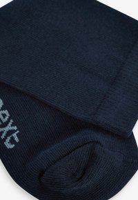 Calzini blu navy realizzati in tessuto strutturato, con punta e tallone rinforzati, e con marchio bianco nell'area della caviglia.