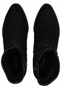 Botas de tobillo de ante negro con punta afilada, cremallera lateral y acentos de costura decorativa. Textura suave con una silueta ajustada.