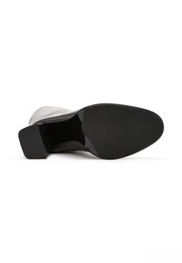 Stivale nero con tacco, tomaia in pelle liscia, punta quadrata, tacco basso a blocco e suola in gomma nera piatta con una leggera lucentezza sul fondo.