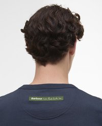 T-shirt de algodão azul-marinho com um rótulo na parte de trás com "A Barbour também ama Paul Smith" em letra branca sobre um fundo verde.