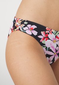 Črn bikini s pisanimi cvetličnimi vzorci v roza in rdeči barvi. Ima izrezano zasnovo z vezavami ob straneh, izdelan iz gladkega materiala.
