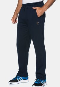 Navy blue sweatpants made of soft fabric, featuring an elastic waistband with a drawstring, side pockets, and a gold JP logo.