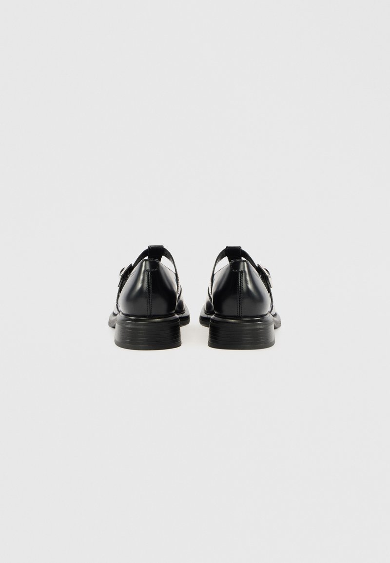 Schwarze Lederschuhe mit glatter Oberfläche, rund zulaufender Spitze und niedrigem gestapeltem Absatz; mit Rückriemen und Schnallendetail.