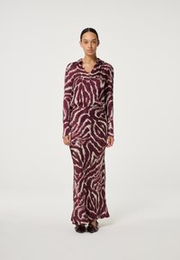 Langes, burgunderfarbenes Blusenset mit Rock, das ein auffälliges, kontrastierendes Tiermuster in Beige zeigt. Hergestellt aus glattem Stoff mit einer lockeren Passform und Kragen.