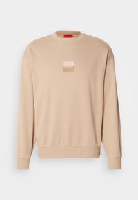 Beige sweatshirt with a round neckline and ribbed cuffs. Features a small square logo in pale colors on the front. Soft, smooth texture.