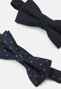 Dos pajaritas: una azul oscuro sólido con una tela texturizada y otra de color marino con puntos naranjas, ambas con correas de tela.