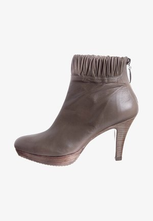 Bottines en cuir marron avec un haut froncé, talon haut et semelle compensée. Présente une fermeture éclair latérale et un talon texturé. Fini lisse.