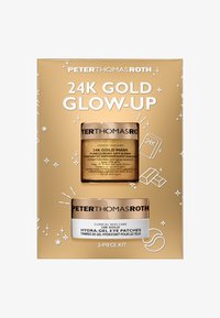 Kit de Glow-Up 24K que incluye una caja dorada con dos productos: una mascarilla dorada y parches para los ojos, cada uno en frascos con acentos dorados y blancos.