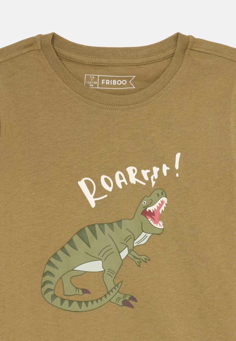 T-shirt vert olive avec une illustration de dinosaure en cartoon et le texte "ROARR !!" en blanc. Tissu doux avec un design classique à col rond.