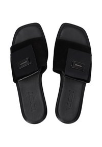 Zwarte schuif sandalen met een zachte suede bovenkant, vierkante neus en een soepele leren zool. Heeft een rechthoekige metalen accent op de band.