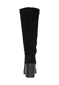 Botas de ante negras hasta la rodilla con un tacón grueso y texturizado y una puntera redondeada. Costuras visibles y un ligero deslizamiento en la parte superior.