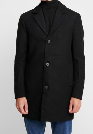 Manteau en laine noire au design ajusté, avec revers crantés et quatre boutons. Doté de poches latérales et d'une finition lisse et texturée.