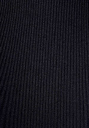 Primo piano della trama di tessuto nero a coste con linee verticali che creano ombre sottili e profondità.