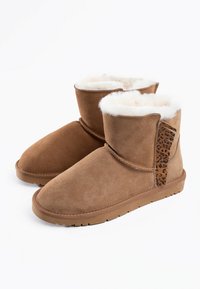 Botas de tobillo de ante marrón con forro de piel sintética, que cuentan con un acento de estampado de leopardo en el lado y una suela de goma resistente.