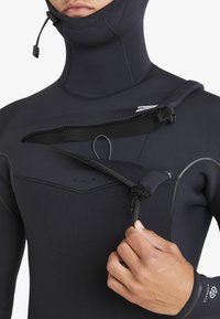 Black wetsuit with a high neck, smooth texture, and a front zipper with adjustable straps. Features silicone accents and flatlock stitching.