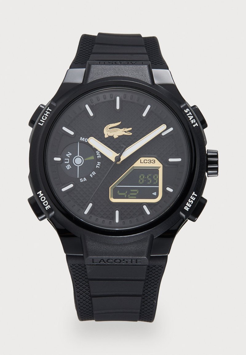Digital watch with a black silicone strap and textured black dial. Features gold accents, white hour markers, and digital display for time.